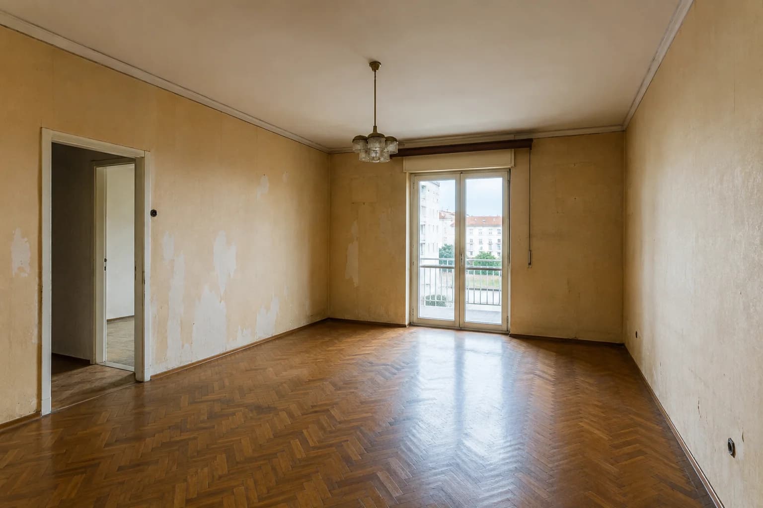 Illustration of the same living room before renovation, with worn walls and flooring